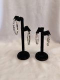 Empress Collection skinny hoop earrings featuring precision-cut Crystal AB Austrian crystals on a high-gloss black display stand