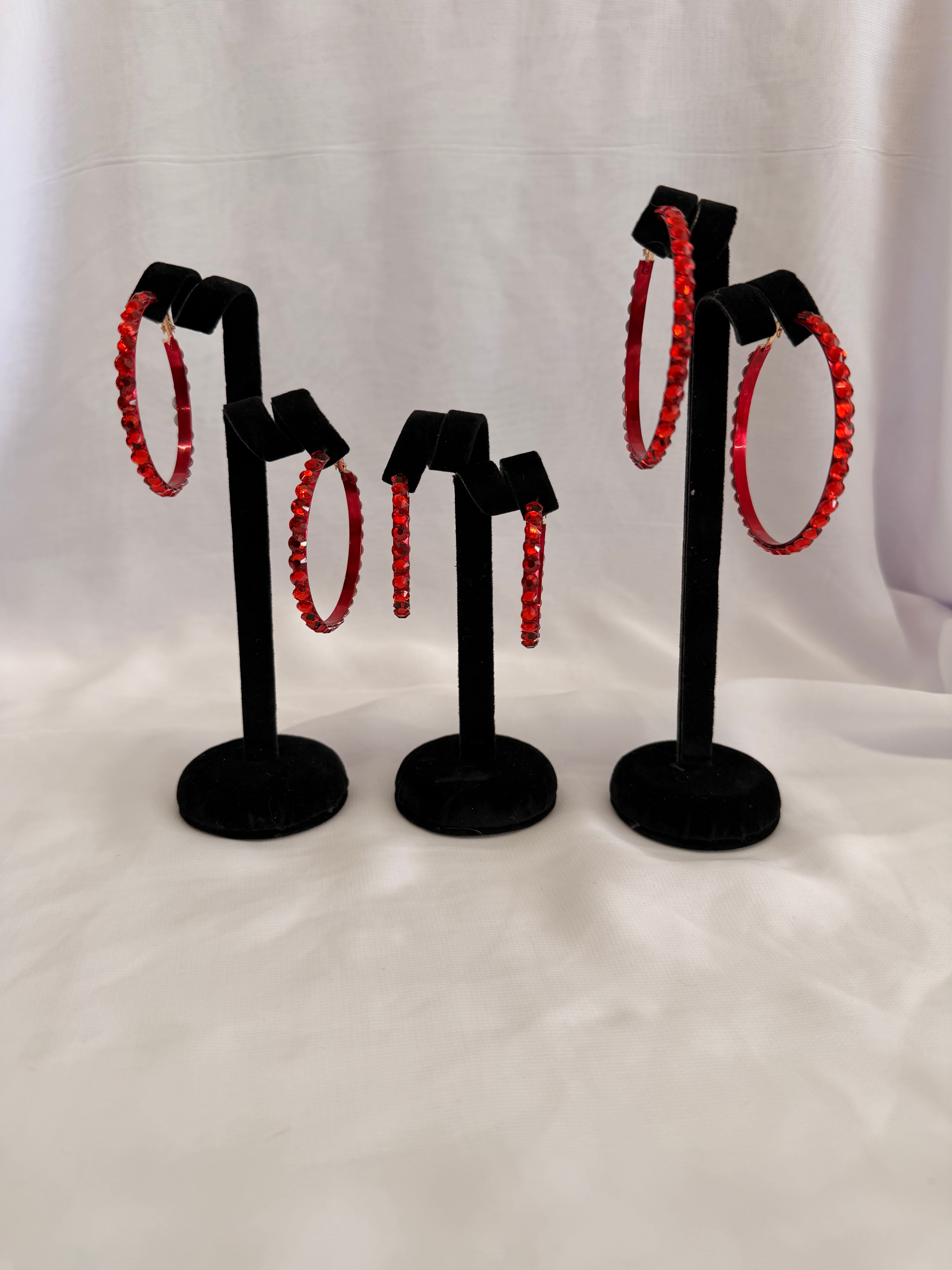 Aurora Collection Siam Red skinny hoop earrings featuring vibrant red performance crystals on a black velvet jewelry display.